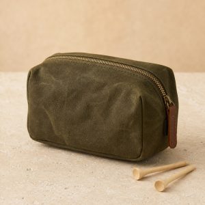 Olive waxed canvas range pouch with a brass zipper and two wooden golf tees